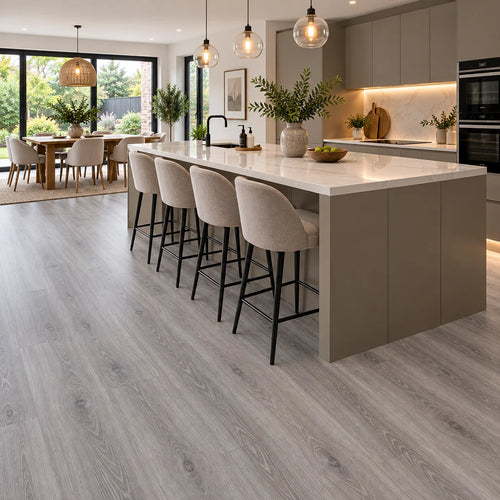 Grey oak LVT flooring running through an open plan kitchen diner with a large island and bar stools