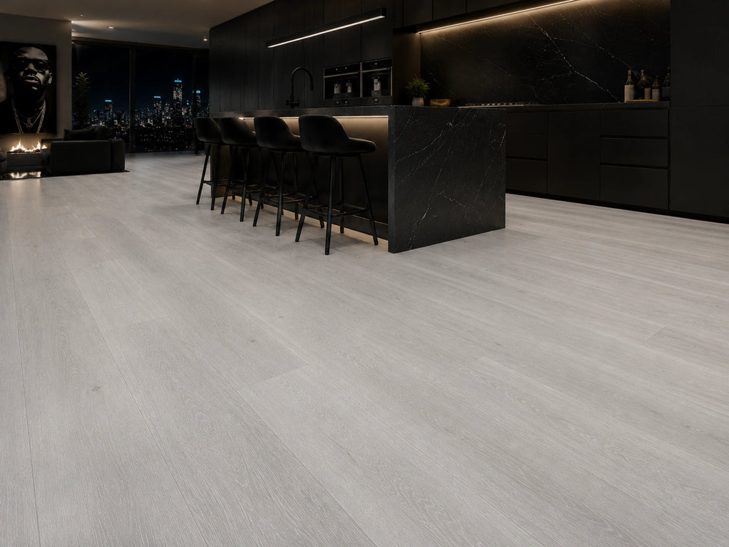 Grey Oak SPC flooring in a dramatic open-plan penthouse kitchen with black marble island, matte black cabinetry and city skyline at night