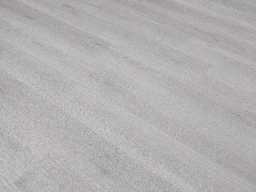 Angled detail shot of Grey Oak SPC flooring showing cool light grey oak grain texture with fine linear wood patterning