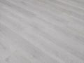 Angled detail shot of Grey Oak SPC flooring showing cool light grey oak grain texture with fine linear wood patterning