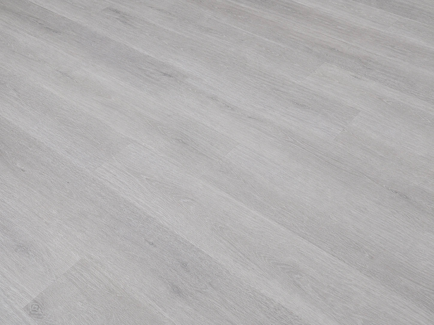 Angled detail shot of Grey Oak SPC flooring showing cool light grey oak grain texture with fine linear wood patterning