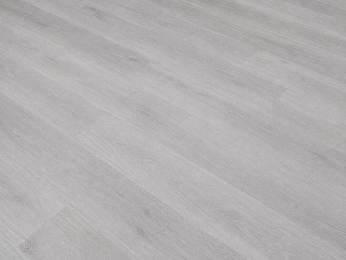 Angled detail shot of Grey Oak SPC flooring showing cool light grey oak grain texture with fine linear wood patterning