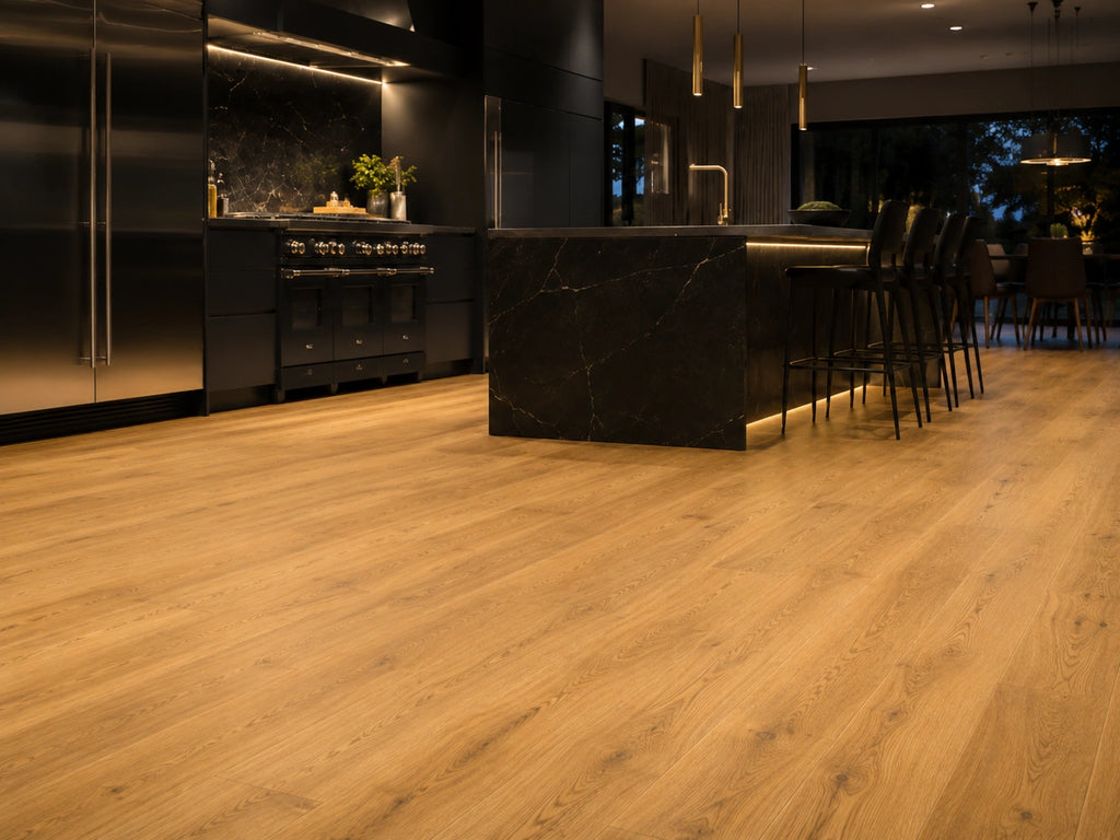 Harvest Oak SPC flooring in a high-end contemporary kitchen with black marble breakfast island, brass pendants and ambient under-cabinet lighting