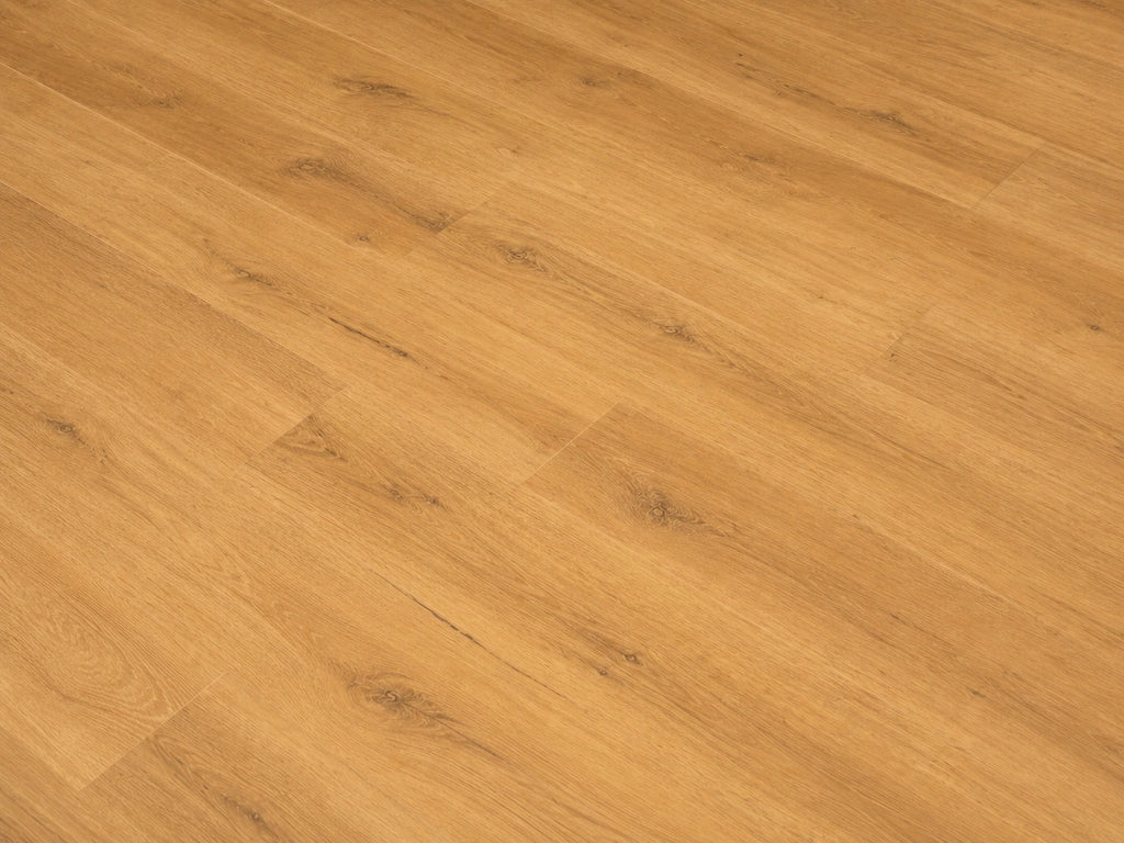 Overhead detail shot of Harvest Oak SPC flooring showing warm honey-toned oak grain with subtle knot detail