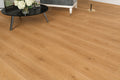Maple Oak SPC flooring laid in a bright living room with a black round coffee table, vintage-style sofa and gold floor lamp