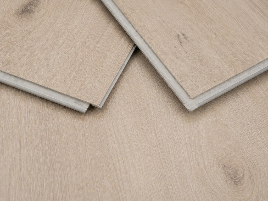 Close-up of Natural Pine Oak SPC click-lock planks showing the rigid core profile, tongue and groove joint and pale linen-toned oak surface finish
