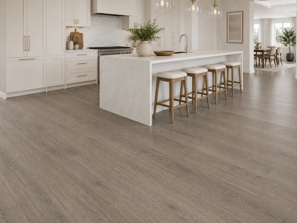 Seasoned Oak SPC flooring laid in a spacious luxury kitchen with white shaker cabinetry, gold hardware, marble splashback and open dining area beyond